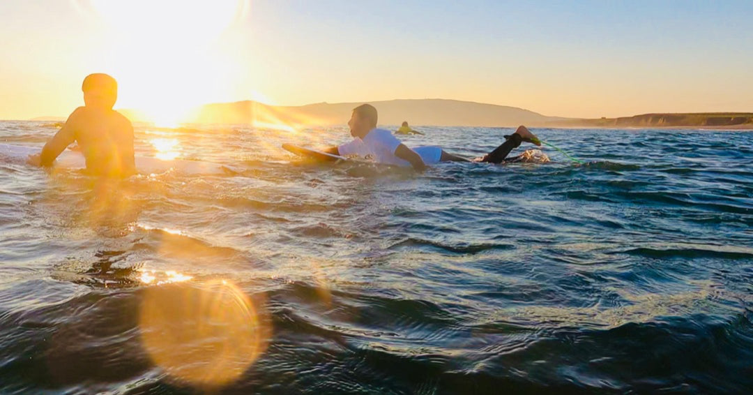 surfer paddling out at sunset at hells mouth north neigyl Wales on a surfboard